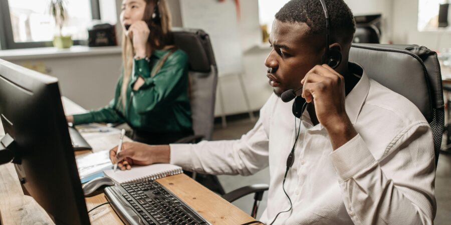 2 customer service members of staff answering mystery shopping calls in an office.
